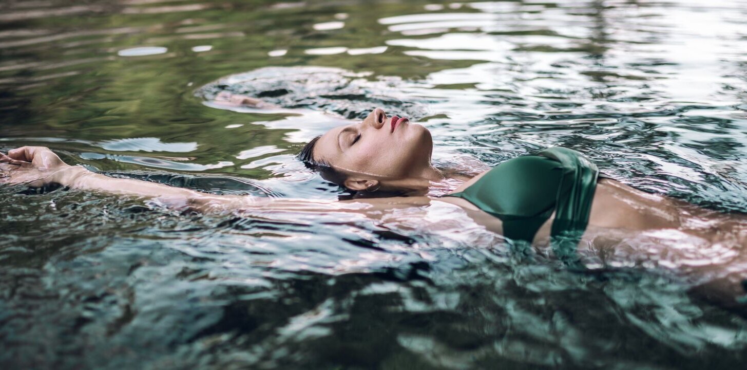 Eine Frau in Bikini lässt sich im wohltuenden Heilwasser treiben.