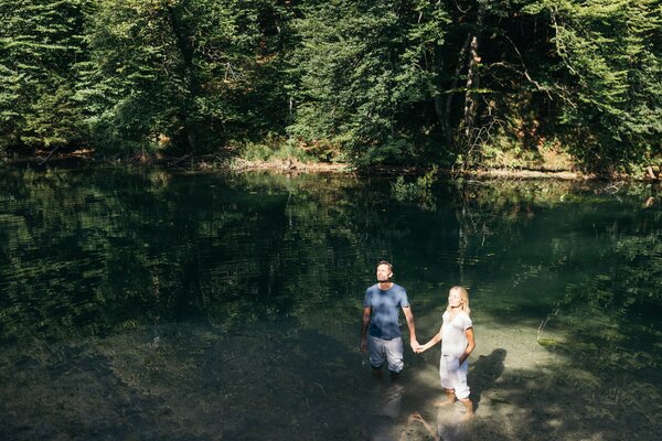 Paar in Wasser Paar steht in der Sonne und hält Händchen im Wasser